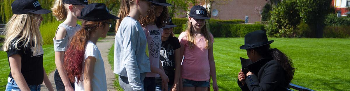 Een groep kinderen gaat tijdens het detective feestje naar buiten voor het ophalen van nieuw bewijs.